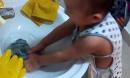 宝宝踩着板凳洗衣服自己尿的